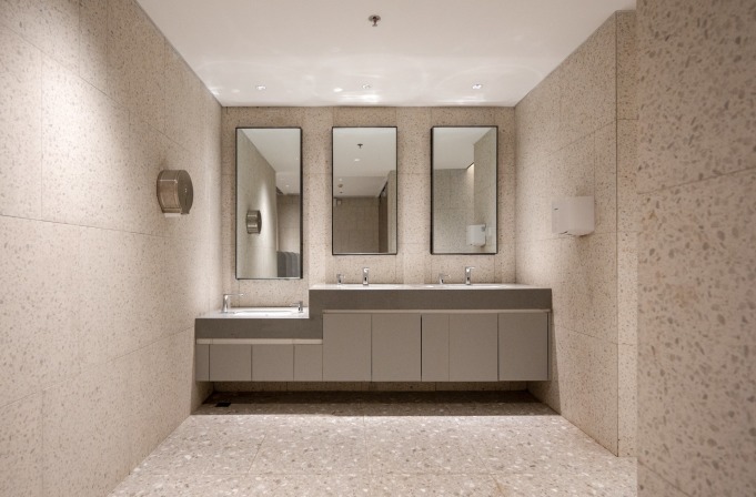 购物中心内现代圆形天花板，中央区域有三角形镜面装饰，周围环绕暖色灯光。